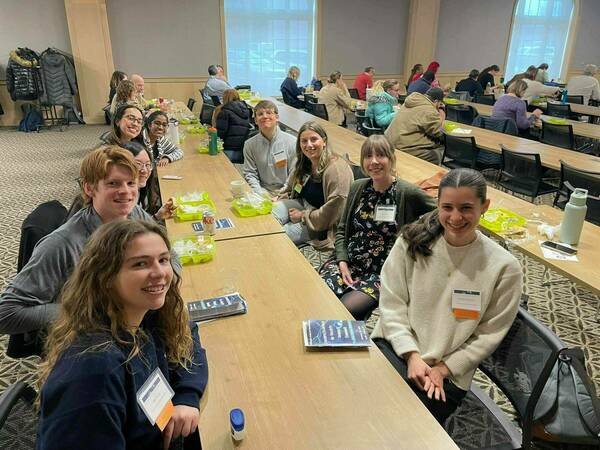 BRAIN Lab undergraduate research assistants sitting with two Notre Dame professors eating lunch at the Neuroscience Impact Summit.
