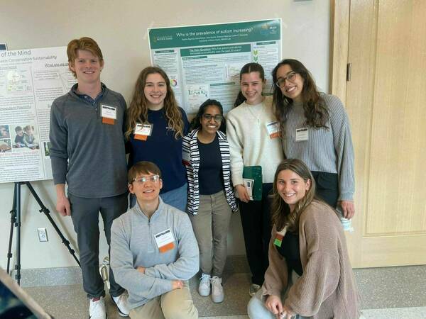All of the BRAIN Lab undergraduate research assistants standing in front of one groups poster at the Neuroscience Impact Summit.